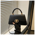 Detalle de bolso en cuero negro mate con cierre giratorio ovalado dorado y asa - Negro