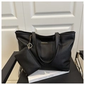 Detail of black leather tote bag with gold logo and matching mini coin purse accessory - Black