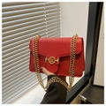 Détail du sac bandoulière en cuir rouge avec motif feuille gaufré et boucle M dorée - Rouge