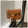 Détail du sac en cuir marron avec motifs floraux gaufrés et boucle dorée en M - Marron