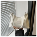 Detalle de bolso plisado crema con anillas plateadas y textura de la etiqueta moda - Blanco