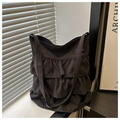 Detalle del diseño de volantes multicapa y textura de lona en bolso negro - Negro