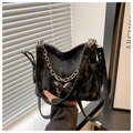 Close-up of black pleated bag featuring a silver chain and metal butterfly buckle - Black