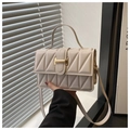 Detail view of a beige quilted leather crossbody bag with elegant gold metal buckle - White