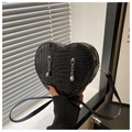 Detalle de bolso bandolera negro en forma de corazón con textura de coco y cadenas - Negro