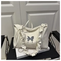 Detail of cream pleated shoulder bag featuring a decorative silver metal butterfly - White