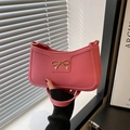 Pink leather shoulder bag with golden bow buckle on a shutter shadow background - Pink