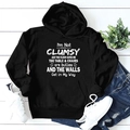 Flat lay of a black loose-fitting hoodie with white text paired with ripped blue jeans - S / Black