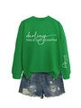 Detail eines grünen Sweatshirts mit weißem Textdruck und zerrissenen Denim-Shorts - S / Grasgrün (Weiße Schrift)