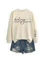 Détail de l'imprimé sur la manche Not The Whole Story sur sweatshirt crème et short en jean - Sable (Police Noire)