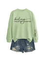 Détail du sweat-shirt vert clair avec imprimé 'darling' et short en jean déchiré - Vert Olive (Police Noire)
