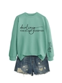 Détail du sweat-shirt vert menthe avec imprimé artistique noir et short en jean - Vert Clair (Texte Noir)