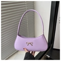 Detalle de bolso baguette lavanda con lazo dorado y acabado en cuero sintético suave y liso - Morado