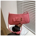 Detailed close-up of a pink baguette bag featuring gold buckle and knot strap detail - Pink