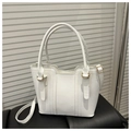 Top-down view of white leather bucket bag with gold ring hardware and stitching details - White