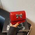 Borsa a tracolla rossa minimalista con grande fiocco argento e catena elegante - Borgogna