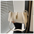 Dettaglio della borsa sottospalla beige con chiusura in metallo dorato e cuciture rifinite - Bianco