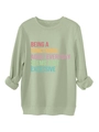 Close-up of light green crewneck sweatshirt with ribbed cuffs and colorful typography - S / Olive Green