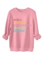 Close-up of pink casual sweatshirt showing rib-knit cuffs and slogan print detail - S / Peach