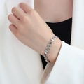 Silver star and geometric link bracelet in stainless steel on female model wrist - Steel Color Star Style (E090)
