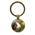 Bronze keychain with round glass pendant featuring a cute guinea pig on white background - Tricolor Guinea Pig with Yellow Flower (JY008596-Copper12)