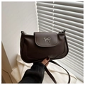 Dettaglio della borsa in pelle marrone con chiusura metallica a fiocco argento elegante - Marrone