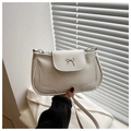 Dettaglio della borsa a spalla in pelle bianca con fiocco argento e tracolla sottile - Bianco