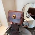 Retro brown faux leather saddle bag featuring a distinctive golden horseshoe buckle - Brown
