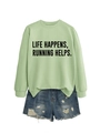 Flat lay of light green Life Happens Running slogan sweatshirt and blue denim shorts - Olive Green (Black Font)