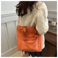 Detail of orange nylon tote bag with front pocket and shoulder strap in casual setting - Orange