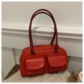 Detail view of a retro red crocodile texture handbag with symmetrical flap pockets and straps - Red