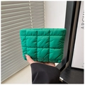 Primer plano de neceser acolchado verde brillante con diseño de cuadros cosidos en la mano - Verde
