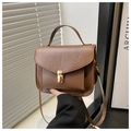 Dettaglio borsa vintage in pelle marrone con chiusura a girello dorata e manico solido - Marrone