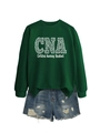 Flat lay of a dark green CNA sweatshirt with leopard print text and denim shorts - Dark Green (White Font)