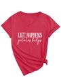Detail of red V-neck t-shirt featuring Life Happens Pilates Helps slogan with hem knot - Red (White Print)