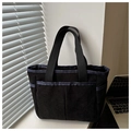 Macro detail of black corduroy tote bag showing striped texture and front storage pocket - Black