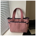 Detailed close-up of pink corduroy tote bag texture and navy blue handles - Pink