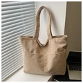 Detail of beige corduroy tote bag showing dual front pockets and soft ribbed texture - Khaki