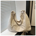 Detalle del bolso hobo de nailon crema con costuras geométricas y hebilla metálica de plata - Blanco