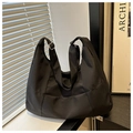 Detalle del bolso hobo de nailon negro con correa ajustable y hebilla metálica - Negro