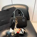 Black mini crossbody bag with leather handle and cute plush dog charm on a leather seat - With Pendant / Black