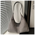 Detalle de bolso de pana gris con textura de rayas verticales y parche de logo de cuero - Gris