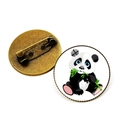 Antike Bronze-Pandabrosche mit niedlichem Panda-Cartoon, der grüne Bambusblätter frisst - Bronze-Panda frisst Bambus mit blauen Augen