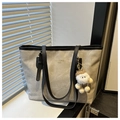 Close-up of grey large tote bag with Luxuryness text and white plush doll pendant - Gray With Pendant