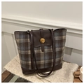 Gros plan du sac cabas vintage à carreaux marron avec une boucle dorée et la lettre N - Carreaux Café