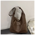 Dettaglio della borsa tote in pelle marrone scuro con trama a grana e tasche laterali - caffè