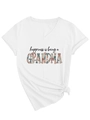 Detail eines weißen V-Ausschnitt T-Shirts mit floralem Grandma-Print und Seitenknoten - S / Weiß