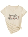 Detail eines beigen V-Ausschnitt T-Shirts mit Blumen-Schriftzug und Seitenknoten - S / Sandfarben