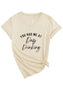 Detail van beige T-shirt met V-hals, 'Day Drinking' tekst en een trendy knoop aan de zoom - S / Zandkleur
