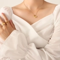 Collana con cigno origami dorato e set di anelli testurizzati su sfondo di tessuto bianco - Collana d'Oro (40+5cm)